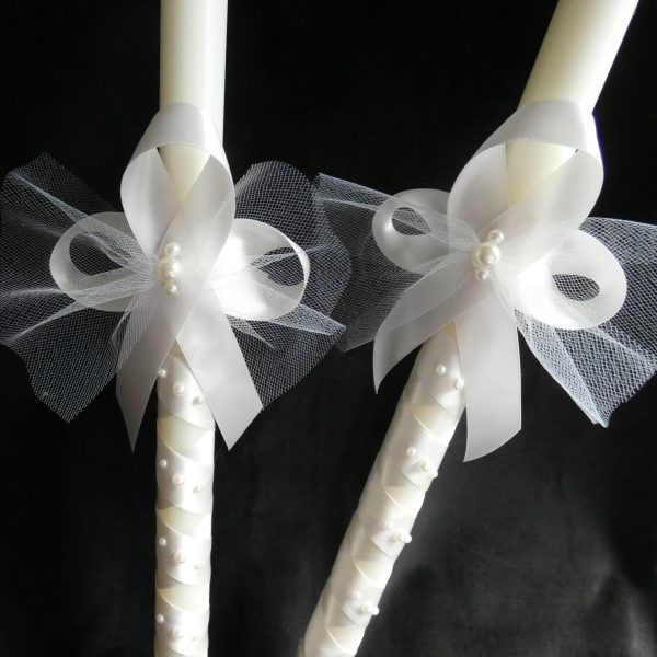 Closeup of ribbon on two ivory Orthodox wedding candles.