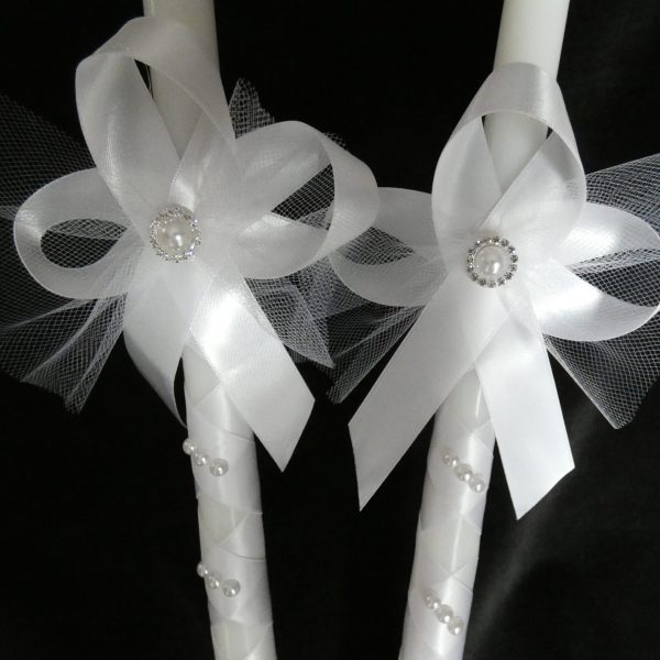 Closeup of ribbon on two white Orthodox wedding candles.