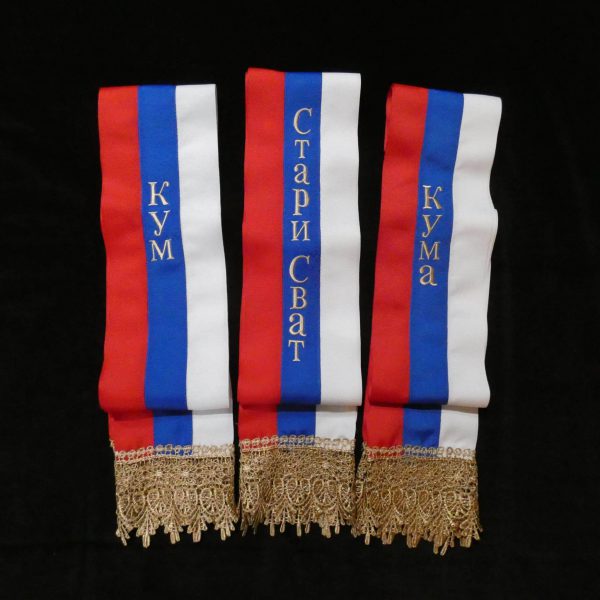 Three tricolor Serbian wedding sashes with gold Cyrillic embroidery.