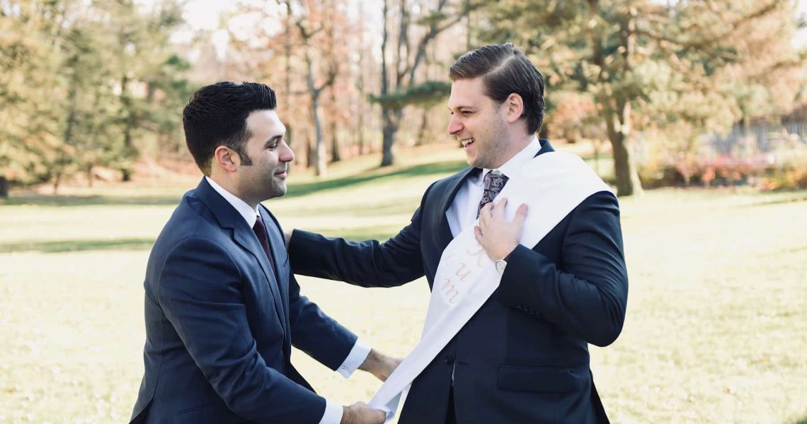 Kum receives his white wedding sash from the groom.